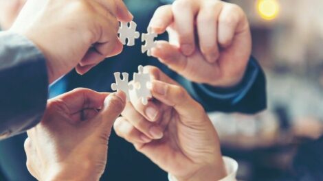 Creative Partner Businessman_team_work_holding_two_jigsaw_connecting_couple_puzzle_piece_for_matching_to_goals_target,_success_and_start_up_new_project_in_office,_select_focus._Business_Concept.