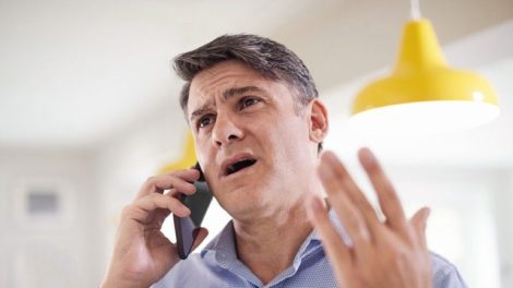 Frustrated_Mature_Man_Receiving_Sales_Call_At_Home