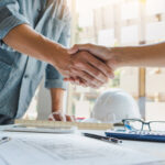 Architect_and_engineer_construction_workers_shaking_hands_while_working_for_teamwork_and_cooperation_concept_after_finish_an_agreement_in_the_office_construction_site,_success_collaboration_concept